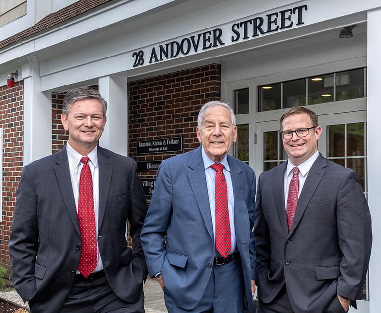 The attorneys of Krasnoo, Klehm & Falkner LLP standing in front of their office